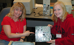 Rosie and Chrissy show off a motherboard.